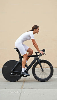 Female Cyclist in White Gear Riding a Modern Road Bike