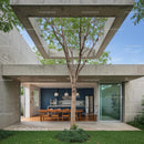 Modern Concrete Structure with Outdoor Dining and Tree Canopy