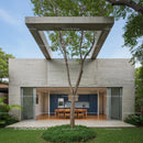 Modern Concrete Structure with Outdoor Dining and Tree Canopy