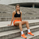 Athletic Woman in Orange Shorts Sitting on Urban Steps