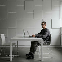 Young Man Working on Laptop in Modern Minimalist Office