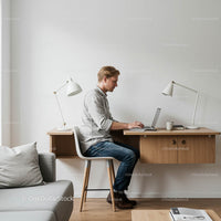 Young Man Working on Laptop in Minimalist Home Office