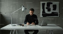 Focused Man Working at Minimalist Desk in Modern Office