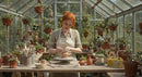 Artisan Crafting Pottery in Lush Greenhouse Studio