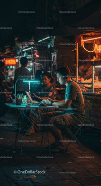 Man Working on Laptop at Night Market
