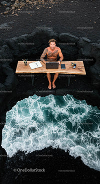 Tattooed Man Working Remotely by Ocean Waves