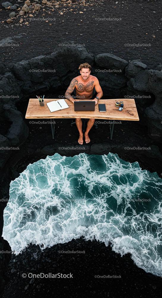 Tattooed Man Working Remotely by Ocean Waves