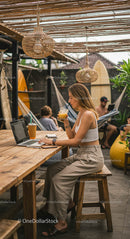 Young Woman Working Remotely in a Bohemian Styled Café