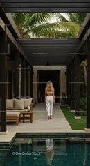 Woman Walking in Tropical Villa with Palm Trees and Pool