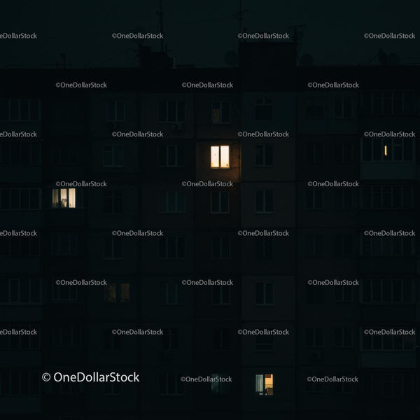 Oświetlone okna w ciemnym miejskim budynku