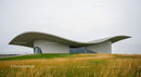 Contemporary Building with Curved Roof on Green Lawn