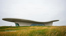 Futuristic Building with Wavy Roof in Grassy Landscape