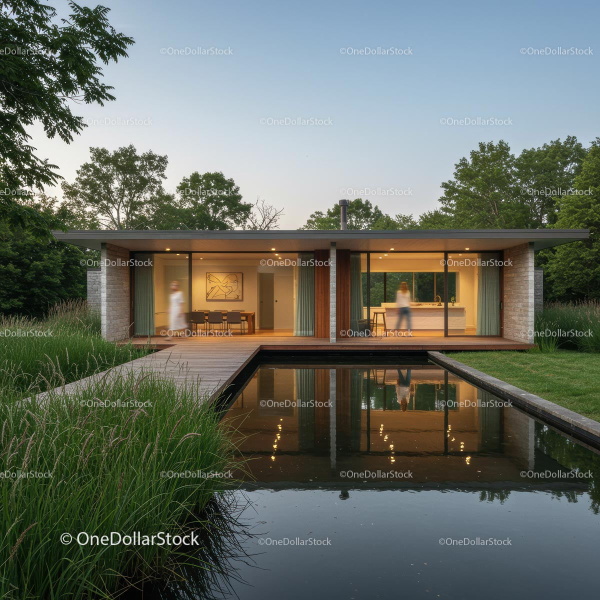 Modern Glass House with Reflecting Pond at Sunset