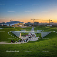 Sunset Over Modern Architecture and Lush Green Hills