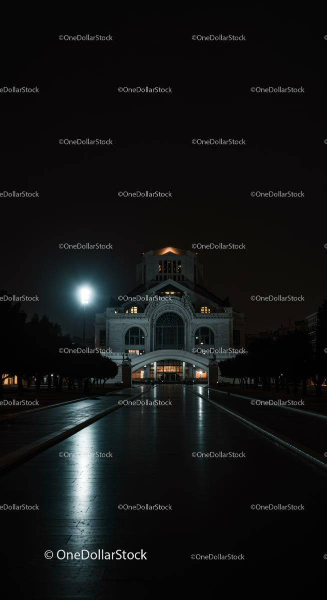 Illuminated Building at Night with Reflective Pathway