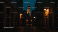 Illuminated Cobblestone Street with Historic City Tower