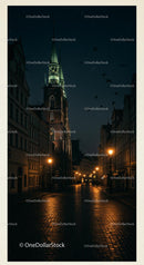 Illuminated Church Tower on Cobblestone Street at Night
