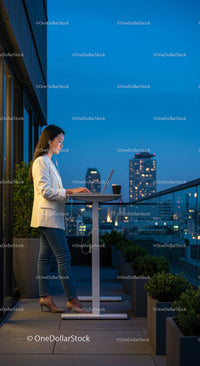Businesswoman Working on Rooftop Balcony with City View