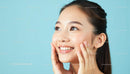 Smiling Woman with Radiant Skin on Light Blue Background