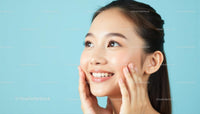 Smiling Woman with Radiant Skin on Light Blue Background