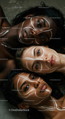 Three Women with Intricate White Face Paint Patterns