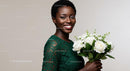 Smiling Woman in Green Dress Holding White Roses Bouquet