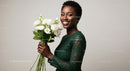 Smiling Woman in Green Dress Holding White Lisianthus Bouquet