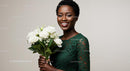 Smiling Woman in Green Lace Dress Holding White Roses