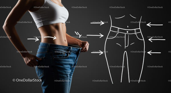 Fit kobieta pokazująca utratę wagi w luźnych dżinsach