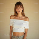 Young Woman in Off-Shoulder Top Against Beige Background