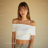 Young Woman in Off-Shoulder Top Against Beige Background