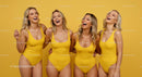 Four Women Laughing Together in Yellow Swimsuits