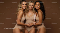 Three Smiling Women in Beige Swimsuits Embracing Friendship