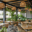 Chic Restaurant Interior with Lush Greenery and Wicker Chairs