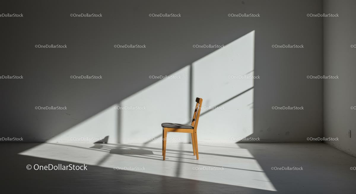 Minimalistyczny pokój z pojedynczym drewnianym krzesłem i dramatycznymi cieniami