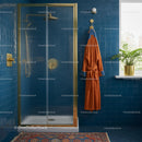 Luxurious Blue Tiled Bathroom with Gold Fixtures and Orange Robe