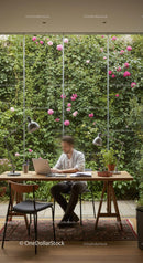 Man Working in Modern Home Office with Green Wall and Pink Flowers