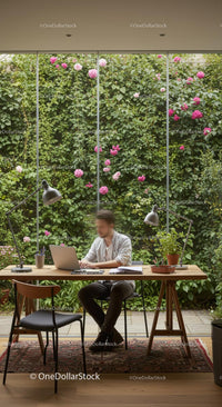 Man Working in Modern Home Office with Green Wall and Pink Flowers