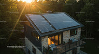 Modern Stone House with Solar Panels at Sunset