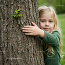 Curious Child Embracing Tree in Verdant Forest