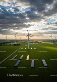 Wind Turbines and Solar Panels in Green Fields at Sunrise