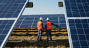 Engineers Inspecting Solar Panel Array in Sunlit Field