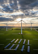 Wind Turbines and Solar Panels in a Green Field at Sunset
