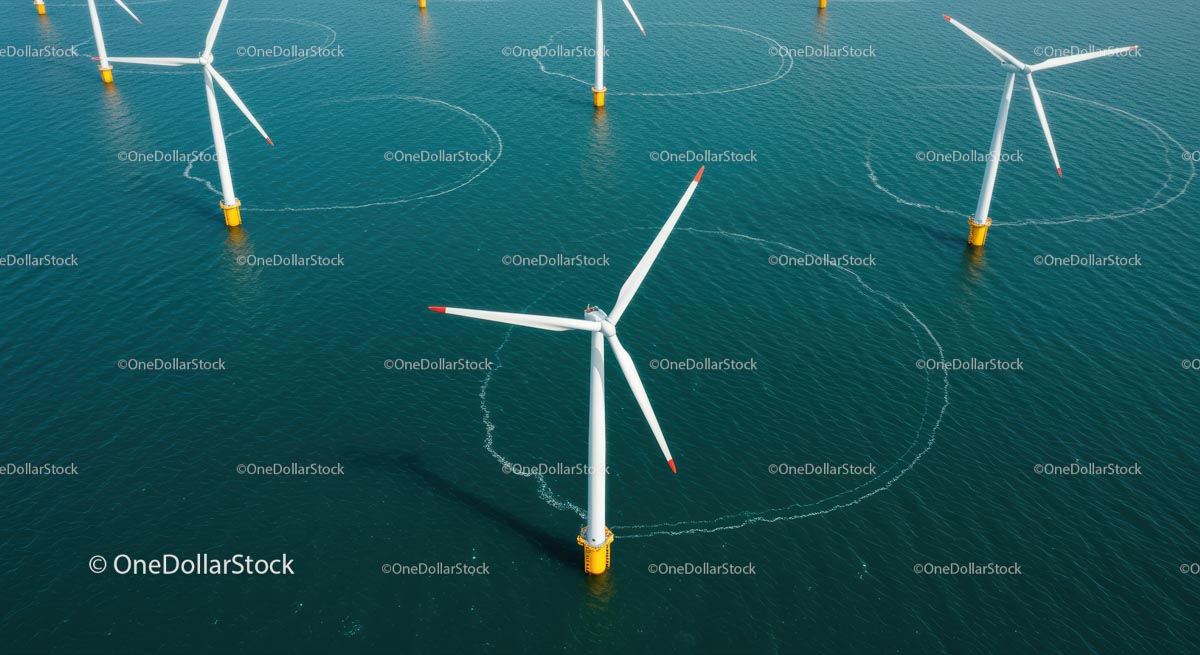 Widok z lotu ptaka na turbiny wiatrowe na morzu w wodach błękitnego oceanu