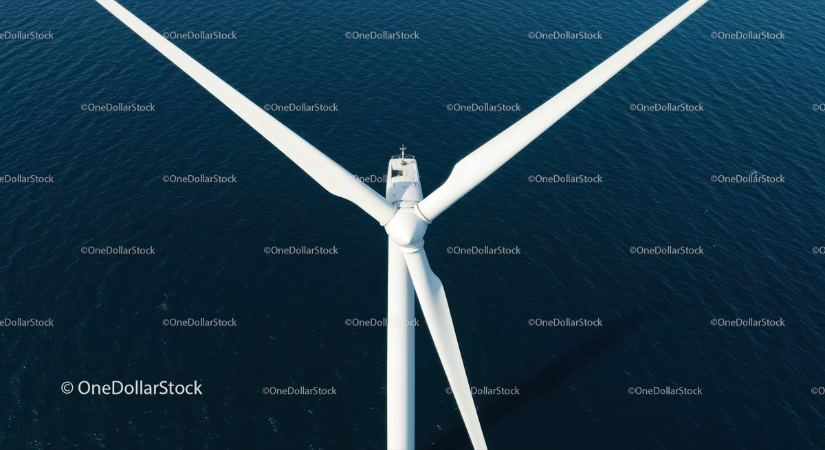 Aerial View of White Wind Turbine Over Blue Ocean