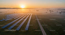 Misty Sunrise Over Solar Farm with Renewable Energy Panels