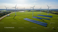 Aerial View of Wind Turbines and Solar Panels in Green Field