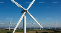 Wind Turbines in Green Fields Under Clear Blue Sky