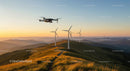Drone and Wind Turbines Over Rolling Hills at Sunrise