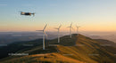 Wind Turbines and Drone at Sunset Over Mountain Landscape